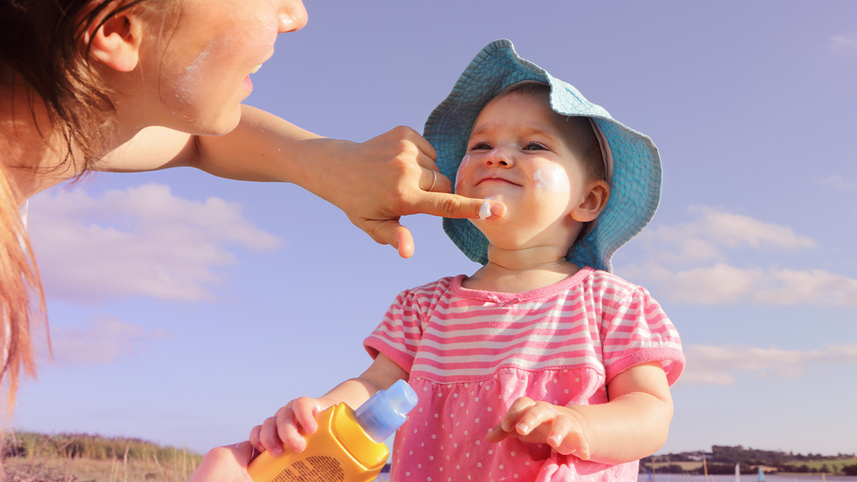 Mom putting sunscreen on baby